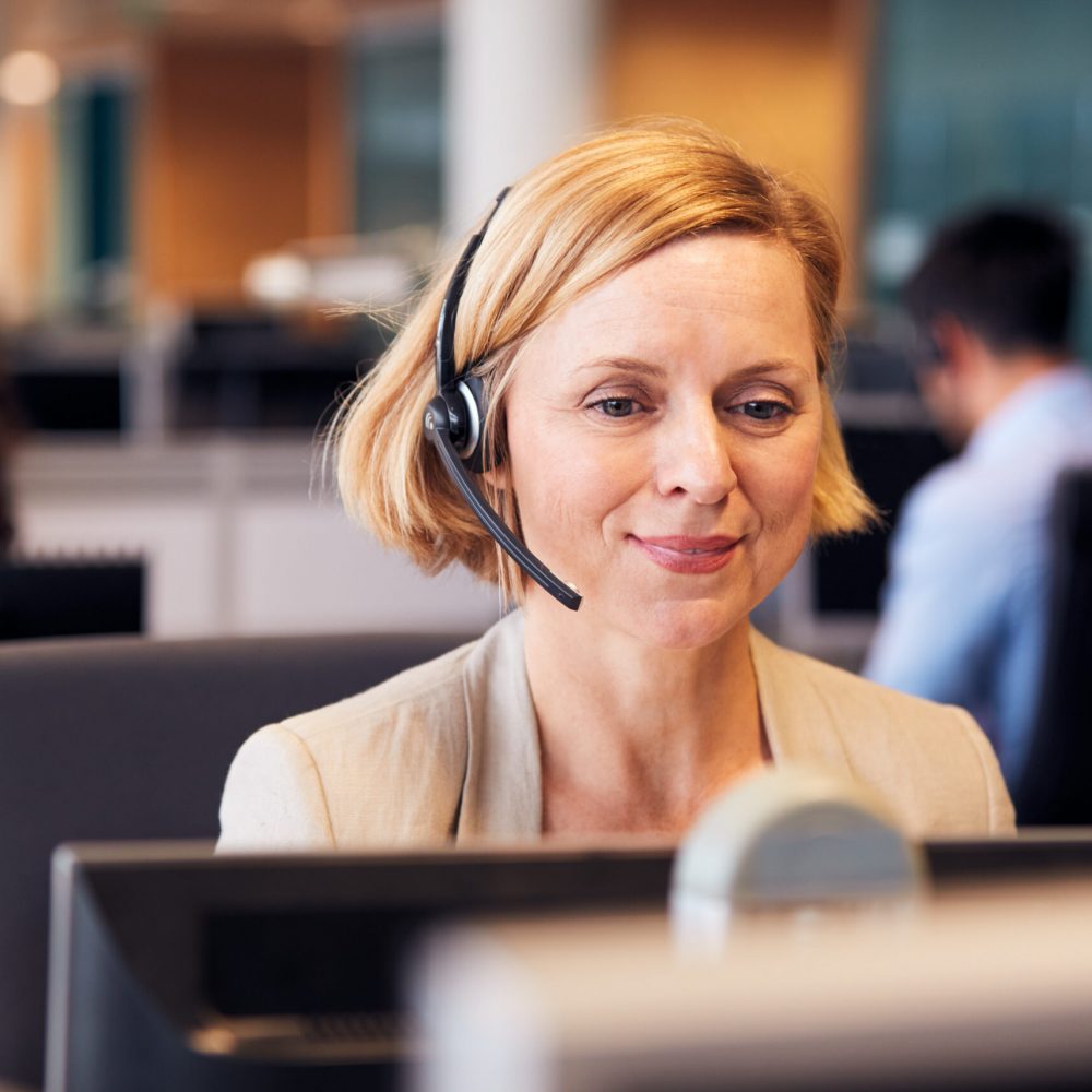 Mature,Businesswoman,Wearing,Telephone,Headset,Talking,To,Caller,In,Customer